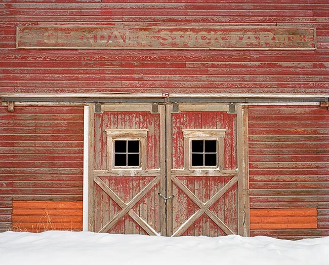 [© Glendale Stock Farm by Judy Hill is described with Color, Warm, Farm, Horizontal, Winter, Stock, Black, Brown, Orange, Reds, White, Colorado, Owl Creek, Snowmass, White River National Forest, Rocky Mountain, Rockys, Barns, Buildings, Historic, Old Buildings, Snow, Snowy, Door, sign, Wall, Farms, Rural, Ranches, Fine Art, retro hit 18054 rate ]