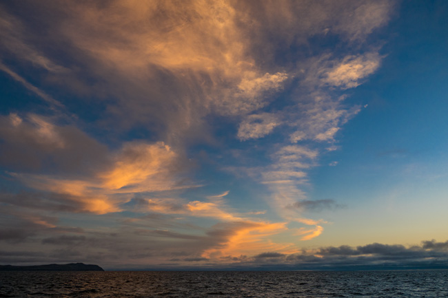 [© Cloud Caligraphy by Judy Hill Lovins is described with Galapagos, Color, Fine Art, Horizontal, Orange, Blue, Sky, Sunset, Sunrise hit 11274 rate ]